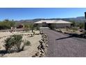 Gravel driveway and desert landscaping leading to a one-story home at 45239 N 16Th St, New River, AZ 85087