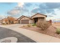 Single story house with a two car garage and desert landscaping at 5711 W Lydia Ln, Laveen, AZ 85339