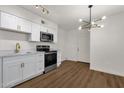 Bright kitchen with white cabinets, stainless steel appliances, and wood floors at 5921 W Hearn Rd, Glendale, AZ 85306