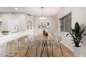 Bright dining area with wood table and chairs, adjacent to kitchen at 6920 E 4Th St # 103, Scottsdale, AZ 85251