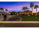 Beautiful home with palm trees and landscape lighting at dusk at 8429 W Sands Ct, Peoria, AZ 85383