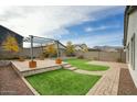 Landscaped backyard with pergola, artificial turf, and paved patio at 19563 W Annika Dr, Litchfield Park, AZ 85340