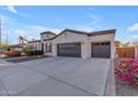 Two-car garage, neutral color scheme, and desert landscaping at 4712 S Onyx Dr, Chandler, AZ 85249