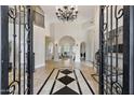 Grand entryway with black iron doors and a stunning chandelier at 6800 E Caballo Dr, Paradise Valley, AZ 85253