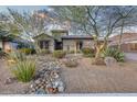 Landscaped front yard with desert plants and rock accents highlights the home's exterior at 8716 W Artemisa Ave, Peoria, AZ 85383