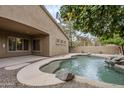 Inviting kidney-shaped pool with waterfall feature and a covered patio at 1060 W Silver Creek Rd, Gilbert, AZ 85233