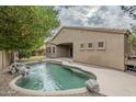 Relaxing kidney-shaped pool with a waterfall feature in the backyard at 1060 W Silver Creek Rd, Gilbert, AZ 85233