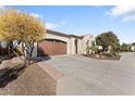 Tan house with brown garage door and drought-tolerant landscaping at 122 E Orange Blossom Path, Queen Creek, AZ 85140