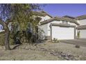 Front view of a charming house with a two-car garage and neatly landscaped yard at 1374 E Kingman Pl, Casa Grande, AZ 85122