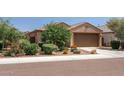 Single-story house with well-manicured landscaping and attached garage at 20138 W Madison St, Buckeye, AZ 85326