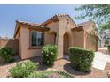 Tan house with arched entryway and neatly landscaped front at 20138 W Madison St, Buckeye, AZ 85326