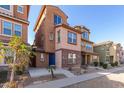 Three-story townhome with blue door and desert landscaping at 2028 N 77Th Ln, Phoenix, AZ 85035