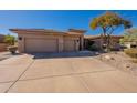 Tan house with a three-car garage and neatly landscaped front yard at 29306 N 70Th Way, Scottsdale, AZ 85266