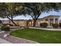 Elegant home exterior with mature trees and a paved walkway at 3038 E Waterman Way, Gilbert, AZ 85297