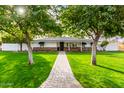 Ranch house with mature trees, brick facade, and a stone pathway at 4017 E Wilshire Dr, Phoenix, AZ 85008