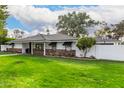 House exterior showcasing a large lawn, mature trees, and basketball hoop at 4017 E Wilshire Dr, Phoenix, AZ 85008