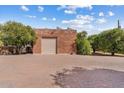 Detached garage with brick exterior and large roll-up door and concrete brick driveway at 4024 E Hermosa Vista Dr, Mesa, AZ 85215