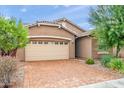 Tan house with a three-car garage and brick driveway at 4125 W Bradshaw Creek Ln, New River, AZ 85087