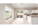 Bright kitchen with granite island, tile flooring, and sliding door access to backyard at 414 E Eason Ave, Buckeye, AZ 85326