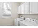 Laundry room with washer, dryer, and white cabinets at 41703 W Mesquite Rd, Maricopa, AZ 85138