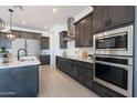 Modern kitchen with dark wood cabinets, stainless steel appliances, and an island at 508 W Tanya Rd, Phoenix, AZ 85086