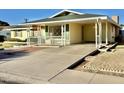 Front view of a yellow house with a covered porch at 5708 W Belmont Ave, Glendale, AZ 85301