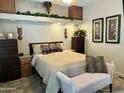 Main bedroom with plush bedding, wood furniture, and decorative wall art at 7750 E Broadway Rd # 175, Mesa, AZ 85208