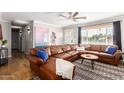 Living room featuring a brown leather sectional and large artwork at 920 E 10Th Pl, Mesa, AZ 85203