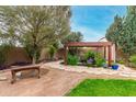 Landscaped backyard with pond, pergola, and bench at 9543 E Palomino Pl, Sun Lakes, AZ 85248