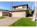 Two-story house with beige exterior, attached garage, and green lawn at 10036 W Montecito Ave, Phoenix, AZ 85037