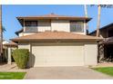 Two-story house with beige exterior, attached garage, and landscaping at 10036 W Montecito Ave, Phoenix, AZ 85037