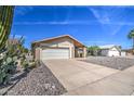 Tan brick single-story home with a two-car garage and desert landscaping at 1014 Leisure World --, Mesa, AZ 85206