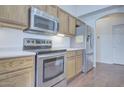 Kitchen with stainless steel appliances including a range, microwave, and refrigerator at 11517 W Coral Snake Ct, Surprise, AZ 85378