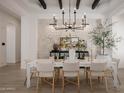 Bright dining room with white table, chandelier, and stone wall at 20177 E Via De Arboles --, Queen Creek, AZ 85142