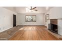 Living room with hardwood floors, fireplace, and ceiling fan at 2326 E Yale St, Phoenix, AZ 85006