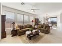 Spacious living room with comfortable seating, large windows, and hardwood floors at 2327 W Firethorn Way, Anthem, AZ 85086
