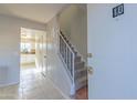 Entryway with staircase and view into kitchen with white cabinets at 3605 W Bethany Home Rd # 10, Phoenix, AZ 85019