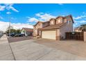 Two-story house with beige exterior, two-car garage, and a gated driveway at 524 N Leoma Ln, Chandler, AZ 85225