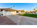 Newly remodeled home with a large grassy yard and a long driveway at 1164 E Westchester Dr, Tempe, AZ 85283