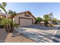 Tan house with a two-car garage and driveway at 14215 W Mountain Laurel Trl, Surprise, AZ 85374