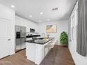 Bright kitchen with stainless steel appliances, black granite countertop, and breakfast bar seating at 14644 W Sand Hills Rd, Surprise, AZ 85387