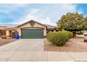 Tan house with a green garage door and landscaped front yard at 15720 W Crocus Dr, Surprise, AZ 85379