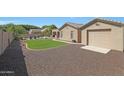 Landscaped backyard with artificial turf and garage access at 18009 W Denton Ave, Litchfield Park, AZ 85340