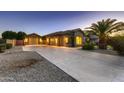 Exterior view of home with three-car garage and long driveway at 18009 W Denton Ave, Litchfield Park, AZ 85340