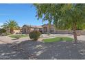 House exterior with lush landscaping and a tree-covered front yard at 18009 W Denton Ave, Litchfield Park, AZ 85340