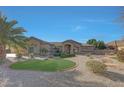 Attractive single-story home featuring desert landscaping with defined lawn area and a clear blue sky at 18009 W Denton Ave, Litchfield Park, AZ 85340