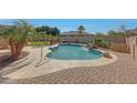Inviting backyard pool area with a waterfall feature, surrounded by lush landscaping and comfortable lounge chairs at 18009 W Denton Ave, Litchfield Park, AZ 85340