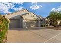 Two-car garage home with drought-tolerant landscaping and a paved driveway at 18135 N Saddle Ridge Dr, Surprise, AZ 85374