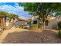 Tan house with desert landscaping, a walkway, and palm trees at 18135 N Saddle Ridge Dr, Surprise, AZ 85374