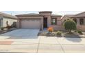 Front view of a house with a two-car garage and drought-tolerant landscaping at 18171 W Glenhaven Dr, Goodyear, AZ 85338